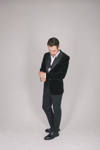 Full length of young man standing against white background