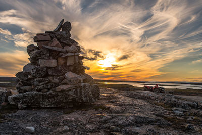 Stack of rocks against sky during sunset