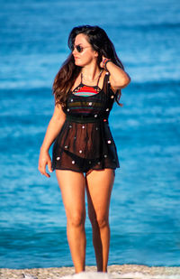 Beautiful young woman standing in sea