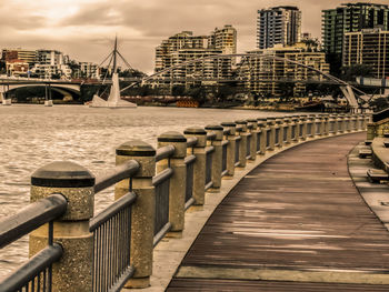 Bridge over river against buildings in city