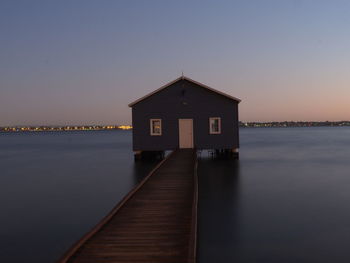 Blue boathouse in perth, westert australian, with city starting to glow