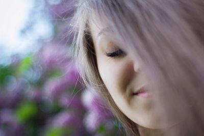 Close-up of smiling shy woman with blond hair