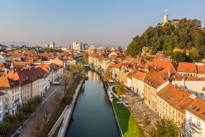 High angle view of river amidst houses in town against sky