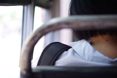 Rear view of woman sitting in bus