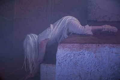 Woman performing on steps in abandoned building