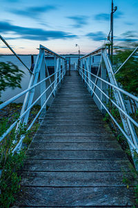 Footbridge over water against sky