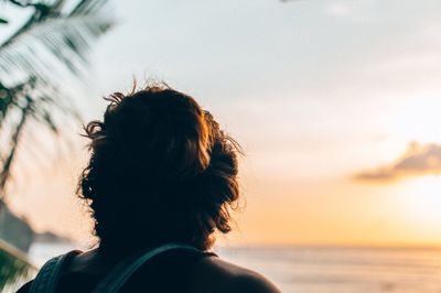 Rear view of silhouette woman at beach during sunset