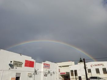 Low angle view of rainbow over buildings in city