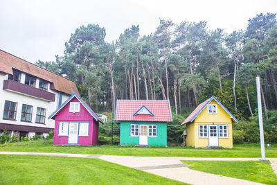 Houses by trees against sky