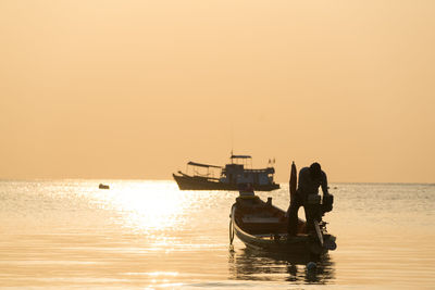 Silhouette boat in sea against sky during sunset