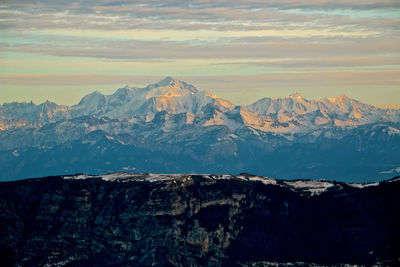 Scenic view of snowcapped mountains against sky during sunset