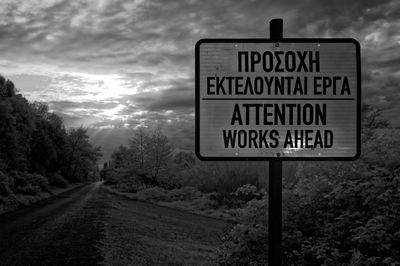 Close-up of road sign against sky