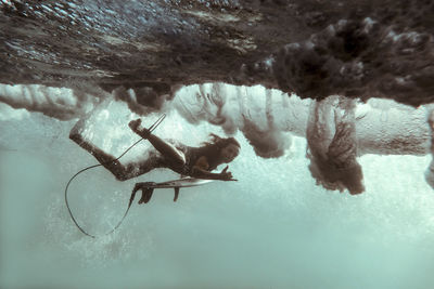 Surfer on surfboard, underwater shot