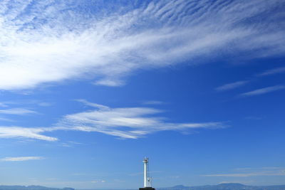 Low angle view of communications tower against blue sky