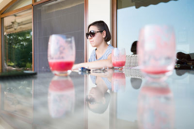 Reflection of woman in sunglasses at mirror