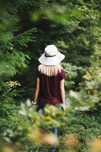 Rear view of woman standing against plants
