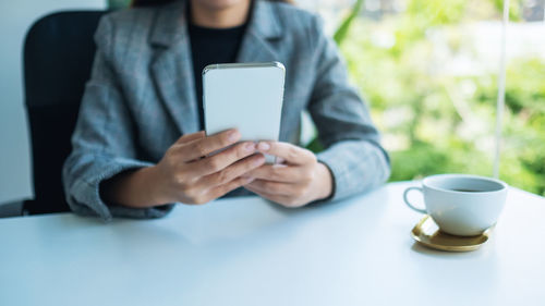 Midsection of woman using mobile phone