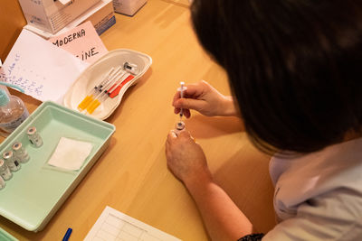 High angle view of woman with syringe