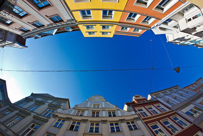 Fish-eye lens view of buildings against clear blue sky