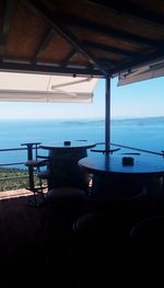 Close-up of chairs in sea against sky