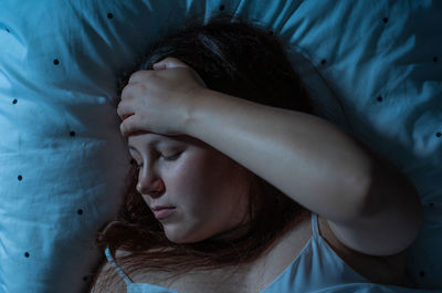 Portrait of young woman sleeping in bed