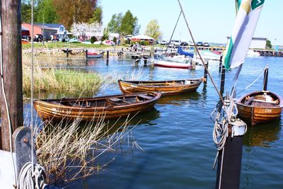 Boats moored at harbor against sky