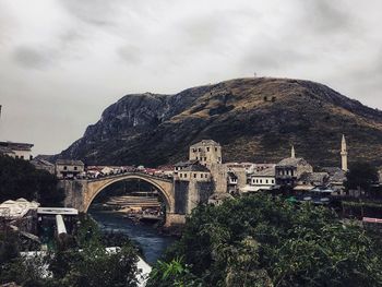 Bridge over mountain against sky