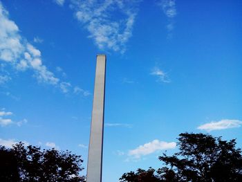 Low angle view of trees against blue sky