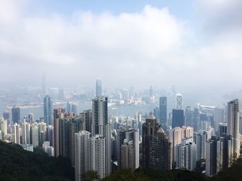 View of cityscape against cloudy sky