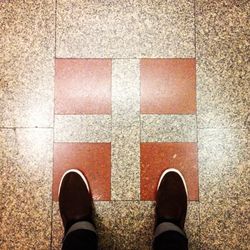 Low section of person standing on tiled floor