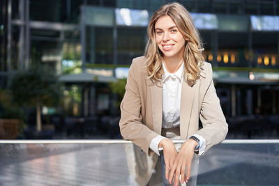 Portrait of young businesswoman standing in city