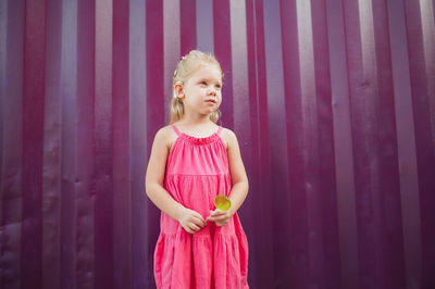 Portrait of girl standing against curtain