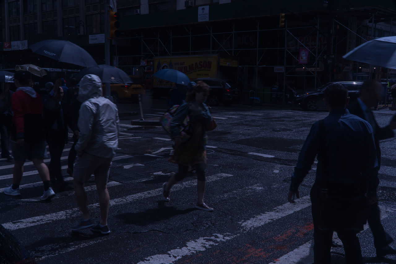 PEOPLE WALKING ON WET ROAD IN RAINY SEASON