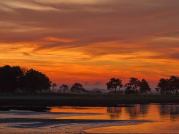 Scenic view of lake against orange sky
