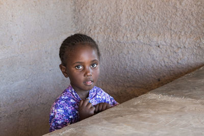 Portrait of boy looking away against wall