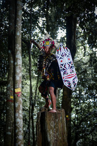 Rear view of woman standing in forest