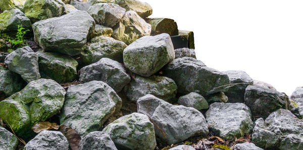 Low angle view of stones on rocks against sky