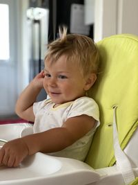 Portrait of cute baby boy sitting on sofa at home