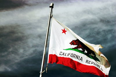 Low angle view of flag flags against sky