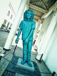 Full length portrait of man standing statue outside building