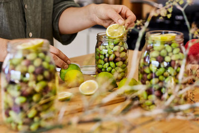 Woman prepares fermented olives in glass jars in the kitchen. autumn vegetables canning. 