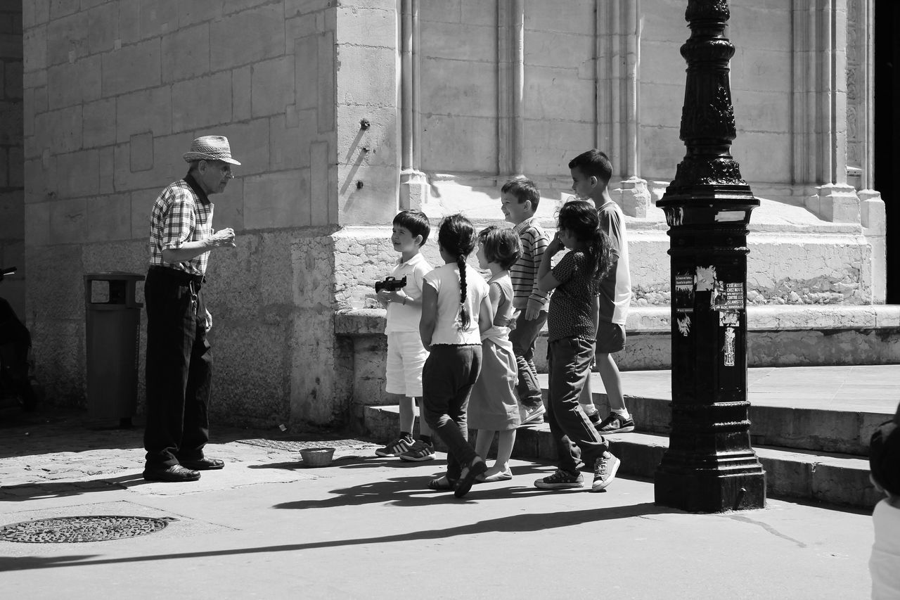 building exterior, architecture, built structure, full length, walking, people, street, lifestyles, city, leisure activity, togetherness, building, rear view, city life, sidewalk, shadow, day