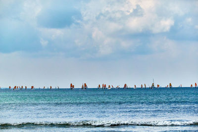 Scenic view of sea with large group of yachts against sky