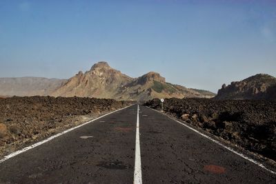 Empty road in desert against clear sky