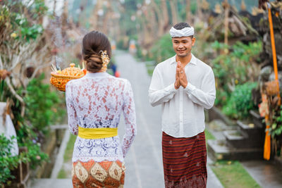 Rear view of couple standing against trees