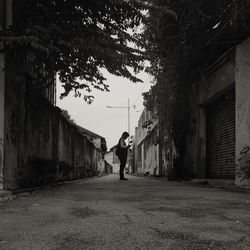 Man walking on footpath amidst buildings in city