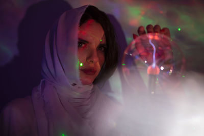 Woman looking away while holding crystal ball