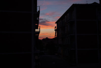 Silhouette buildings against sky at sunset