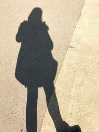 Shadow of person holding umbrella