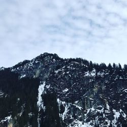 Low angle view of snowcapped mountains against sky